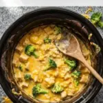 Crockpot broccoli cheddar chicken served in a bowl with herbs