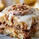 Crockpot gooey cinnamon roll dump cake, topped with icing and cinnamon sugar