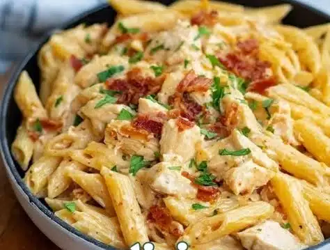 Bowl of Easy Crack Chicken Penne with creamy sauce and toppings