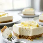 No-Bake Lemon Cheesecake Bars topped with lemon zest and fresh berries.