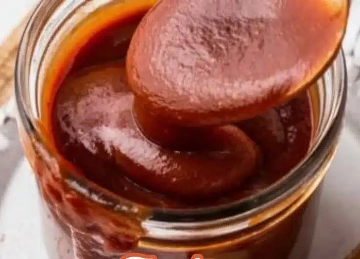 Variety of homemade barbecue sauces in jars on a wooden table