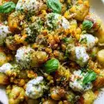 Plate of brown butter corn pesto gnocchi with lemony whipped ricotta.