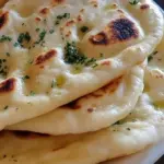Freshly baked homemade garlic naan brushed with butter and garlic