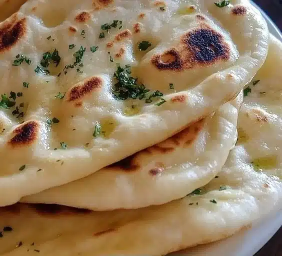 Freshly baked homemade garlic naan brushed with butter and garlic